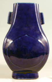 Декоративна китайська порцелянова ваза сплющеної по боках форми із зображенням  стилізованого рельєфного плоду персика на тулубі, на передній та задній сторонах. На шиї дві прямокутні полі ру
