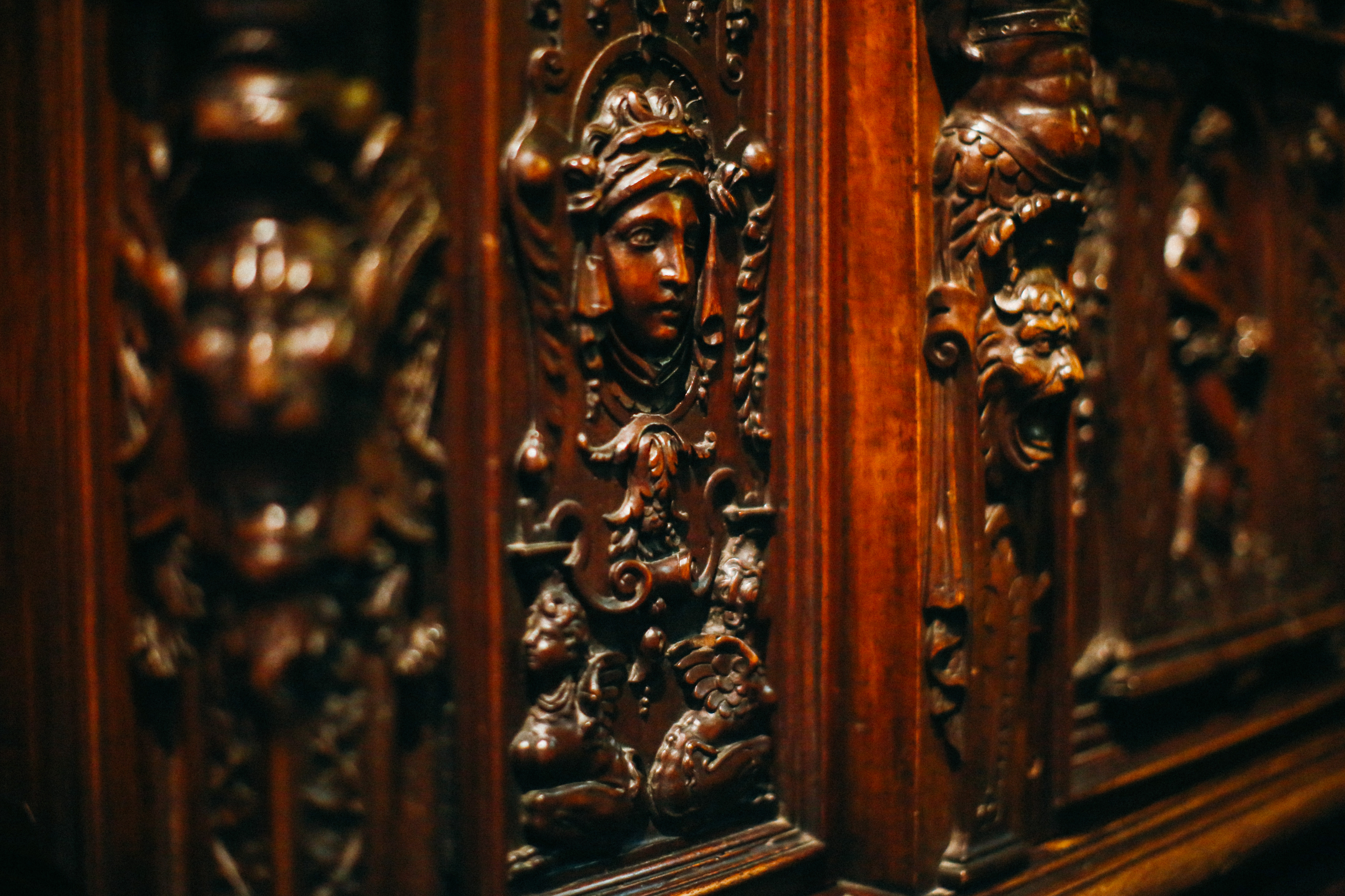 Фото. Фрагмент різьблення дерев’яної шафи креденси - маскарон (людська голова без тулуба, з рослинним орнаментом навколо)