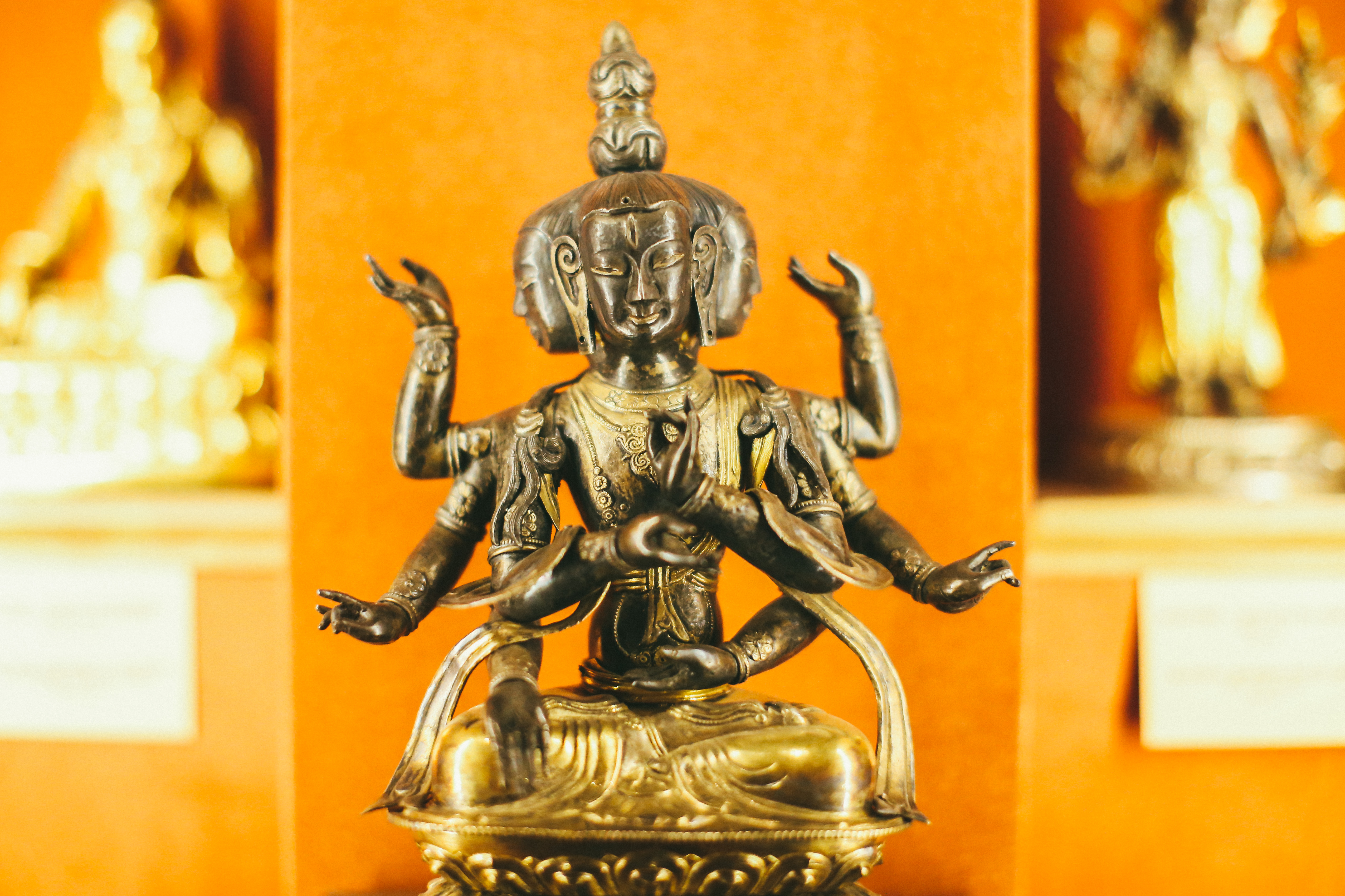 Фото. Експонат музею: бронзова скульптура триголового божества з чотирма парами рук