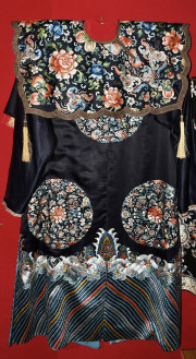 Китайський парадний чоловічій одяг у вигляді довгої кофти с прямокутним коміром. Одяг декоровано зображеннями гори, хвиль, композицій з квітів та персиків і кажанів.