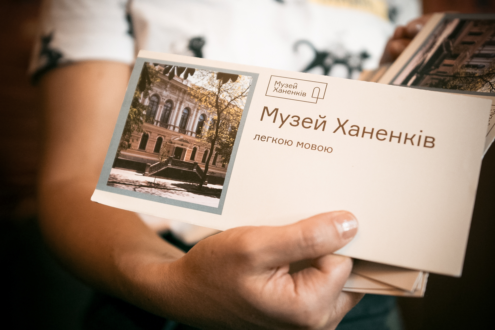 Брошуру "Музей Ханенків легкою мовою" тримає одна з учасниць програми.