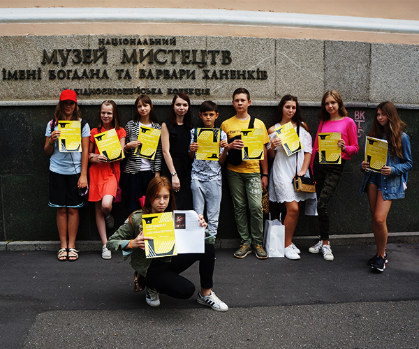 Фото. Діти з сертифікатами про завершення курсу позують на вулиці на фоні фасаду музею